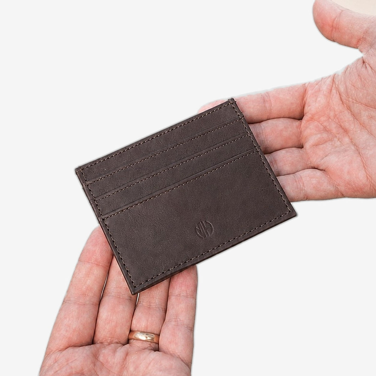 Card Wallet aus Leder in Braun in der Hand #Farbe_Brown