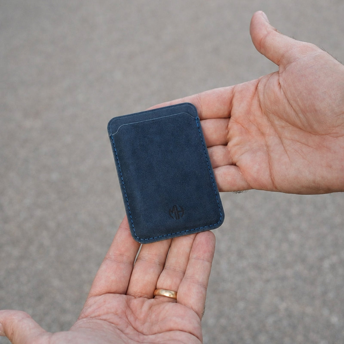 MagSafe Wallet aus Alcantara in Blau in der Hand #Farbe_Blue
