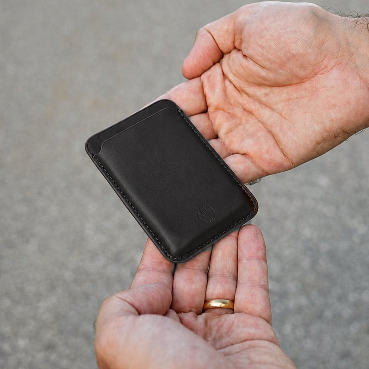MagSafe Wallet aus Leder in Schwarz in der Hand #Farbe_Black