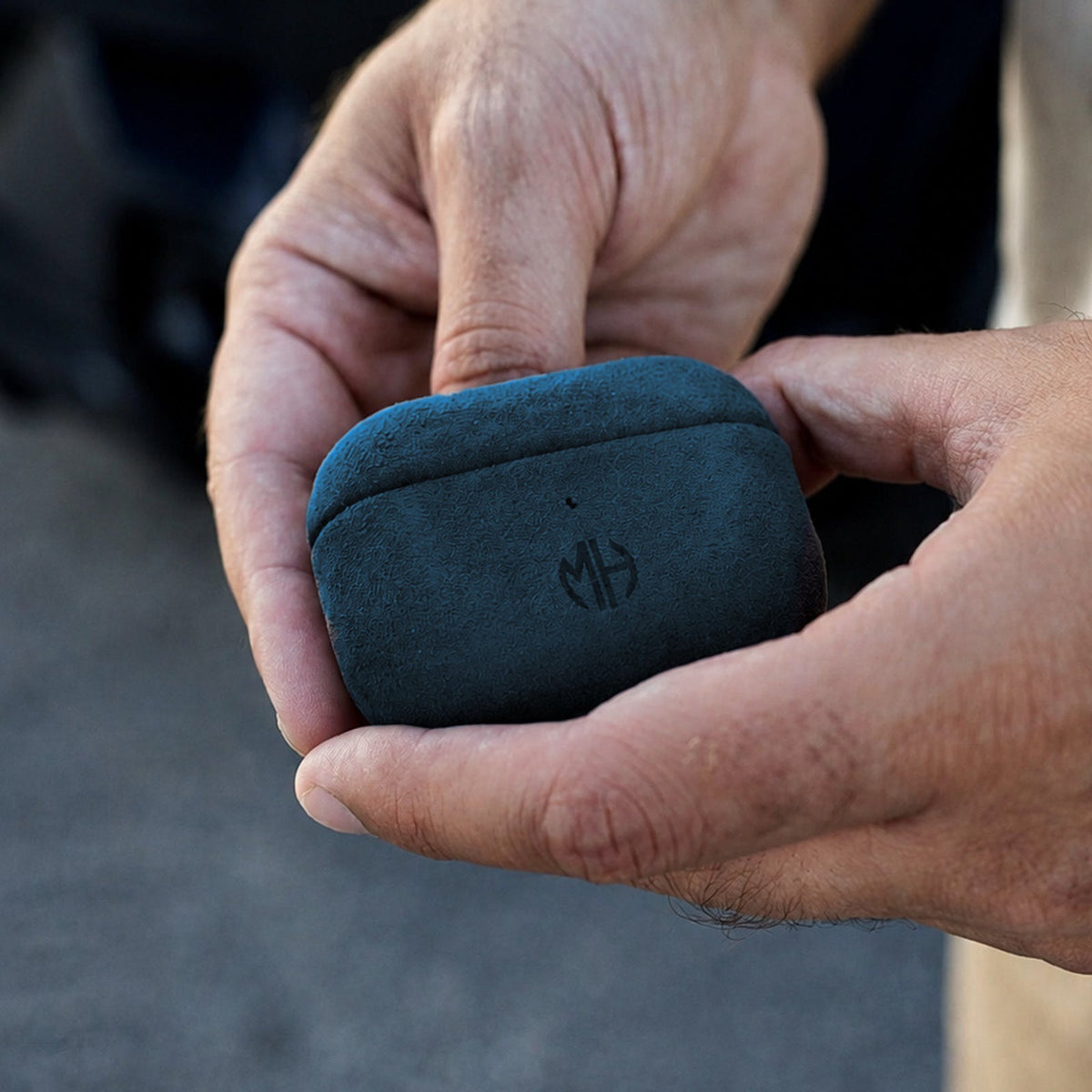 AirPods Case aus Alcantara in Blau in der Hand #Farbe_Blue