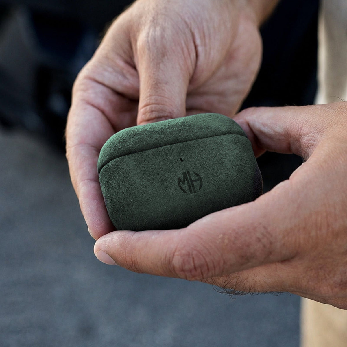 AirPods Case aus Alcantara in Grün in der Hand #Farbe_Green