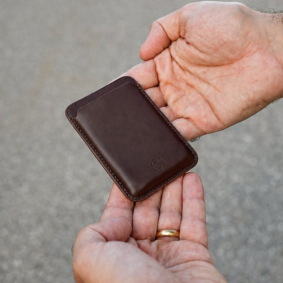 MagSafe Wallet aus Leder in Braun in der Hand #Farbe_Brown