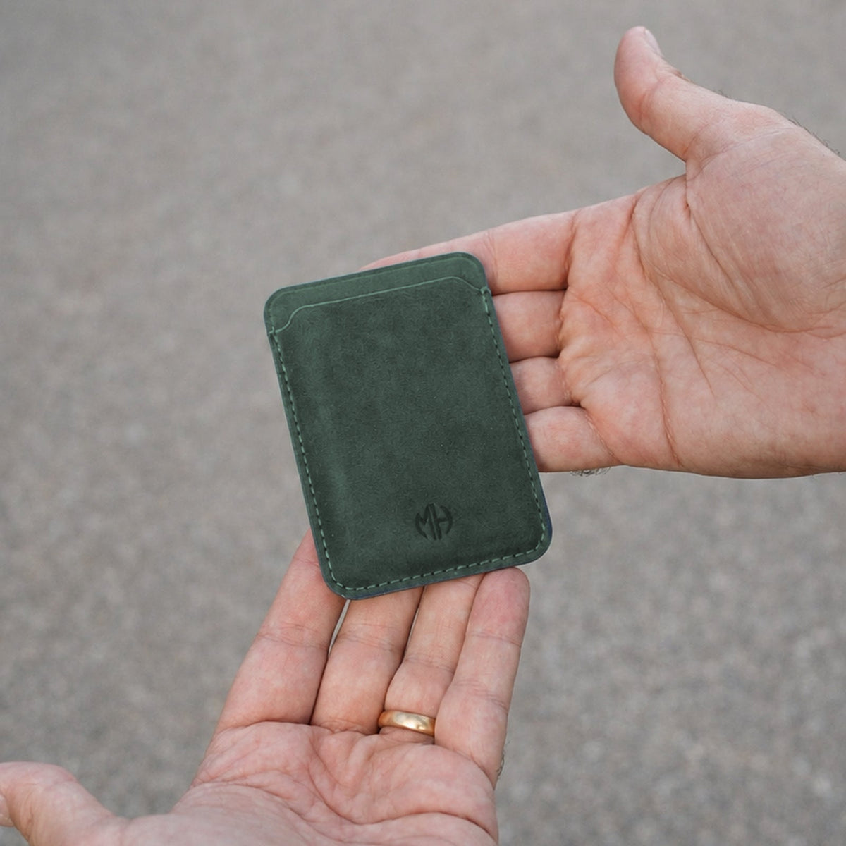 MagSafe Wallet aus Alcantara in Grün in der Hand #Farbe_Green
